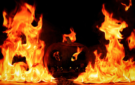 The concept of Halloween. The evil terrible pumpkin is burning in the hellish tongues of flame. Jack Lantern in the middle of the fireの写真素材