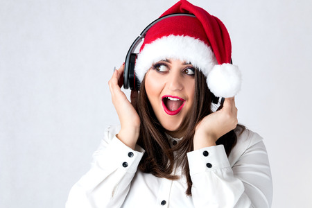 Spirit of Christmas thick girl in Santa Claus cap model XXL, woman plus size in lingerie fat Santa listen music with headphonesの写真素材