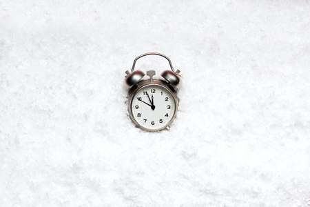 Alarm Clock on white snow, almost midnight の写真素材