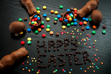 Easter concept painted and chocolate eggs, sweets, drops, candys, bunny for holiday with place for...