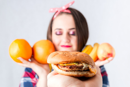 Unhealthy food fat woman concept, Hungry girl XXL wish bad food, Model plus size hold burger centimeter female well-fed fatty stomach shirt web design banner poster isolated place for text の写真素材