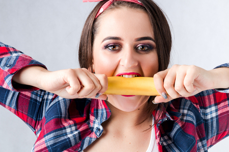 Healthy food fat woman concept, Hungry girl XXL say no bad food, Model plus size biting banana female well-fed fatty stomach web design banner poster isolated place for text loss weight want be thinの写真素材