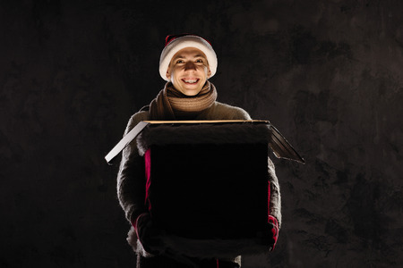 Christmas gift concept. Man in santa hat bring gift for you. Attractive man hold box.  Christmas and...