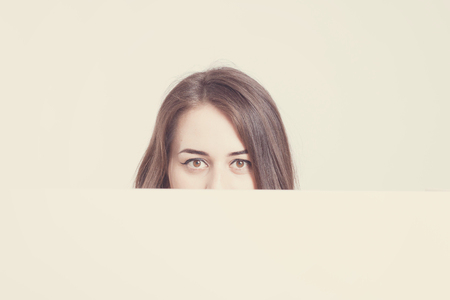 Model plus size with sweet donut, happy surprised girl posing, in black bodysuit. XXL female on light background with white board with space for textの写真素材