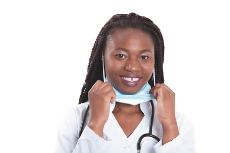 Female american african doctor, nurse woman wearing medical coat with stethoscope and mask. Happy excited for success medical worker posing on light backgroundの写真素材