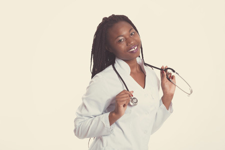 Female american african doctor, nurse woman wearing medical coat with stethoscope. Happy excited for success medical worker posing on light background isolatedの写真素材