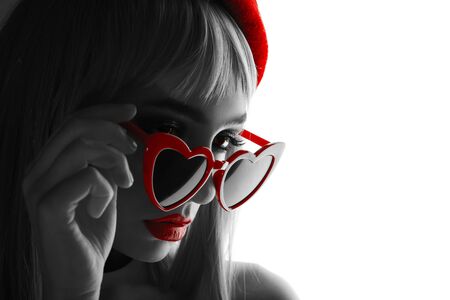 Girl Frenchwoman in a red beret with red glasses heart with big beautiful eyes in the interior loft studio. Woman in a red jacket. Fashionable female with white hairの写真素材