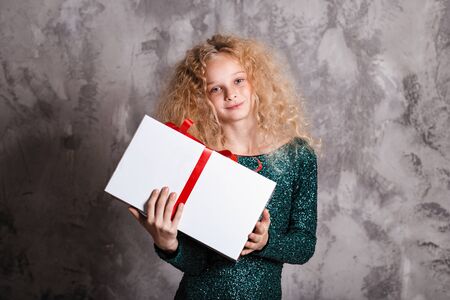 Merry Christmas and happy new year! happy girl with big present in hands looking in camera and smilingの写真素材