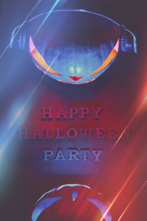 Halloween concept. Two pumpkins in headphones, with a warm and cold glow, a poster for a party with an inscriptionの写真素材