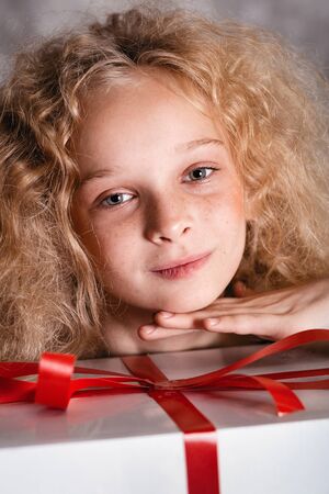 Merry Christmas and happy new year! happy girl with big present in hands looking in camera and smiling. Close portraitの写真素材
