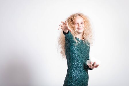 Merry Christmas and happy new year! happy girl with snow balls in hands looks very pleased. Close portrait isolated on white background. Girl throw snowballの写真素材