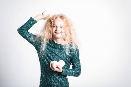 Merry Christmas and happy new year! happy girl with snow balls in hands looks very pleased. Close portrait isolated on white background. Girl throw snowballの写真素材