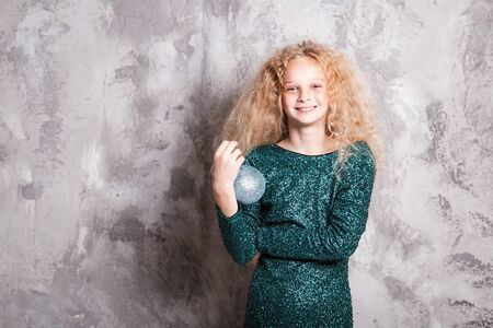 Merry Christmas and happy new year! happy girl with big ball toy in hands looks very pleased. Close portraitの写真素材
