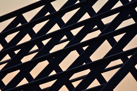 Steel frame roof house silhouette on sunset background.の写真素材