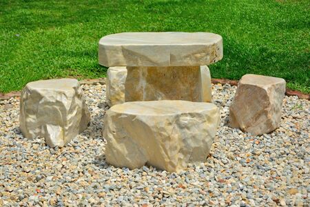 Marble table on pebbles ground in garden.の写真素材