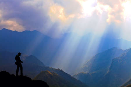 Silhouette standing on mountain with sunlightの素材