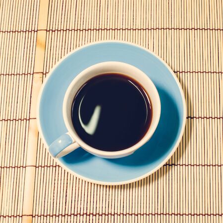 Black coffee put on floor, vintage stylized photoの写真素材
