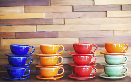 Colorful coffee cups on brick wall backgroundの写真素材