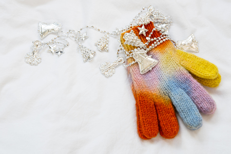 Christmas rainbow knitted mittens with christmas decoration on white backgroundの写真素材