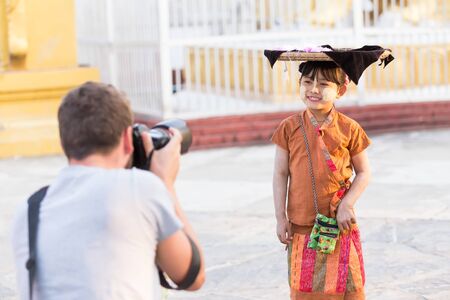 MANDALAY,MYANMAR-FEB 18:Girl sells flowers for tourist on Feb 18,2015 in Kuthodaw temple-Mandalay,Myanmar.のeditorial素材