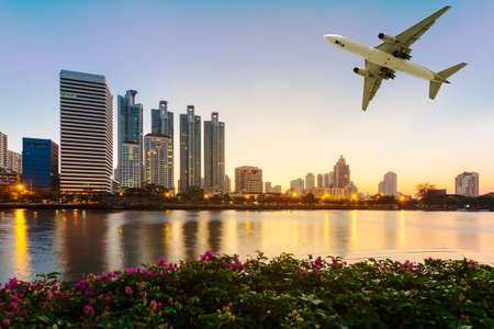Modern building with flower and airplane under the sky at twilight in Bangkok, Thailand.の写真素材