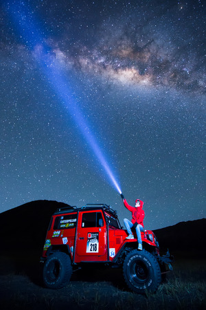 BROMO, INDONESIA - June 22 : 4x4 Jeep for rent with traveller among the Milky way over the bromo volcano on June 22, 2015 in Java, Indonesia. Mount Bromo is one of the most visited tourist attractionsのeditorial素材