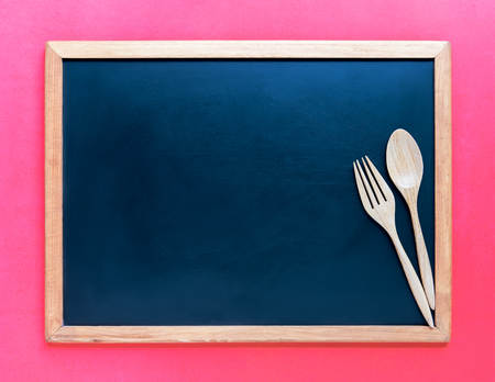 Wooden spoon and fork on blackboard. Use for background in kitchen and food concept.の写真素材