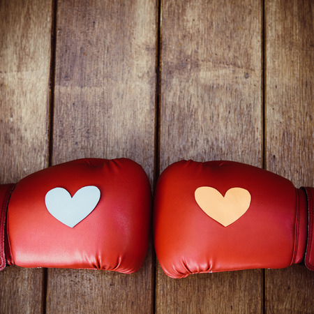 Hearts on red boxing gloves on wood. Conceptual image of fight for love.の写真素材