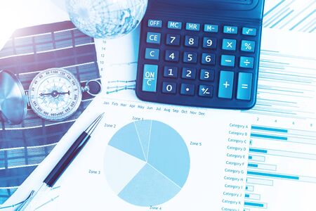 Graphs, charts, calculator, pen, compass on business table. The workplace of business people. Blue color tone.の写真素材