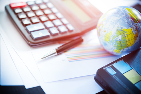 Business analyzing investment charts with laptop, calculator, pen. Accounting. Vintage filtered.の写真素材