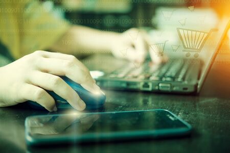 Close up of people shopping Online With computer and mobile phone. Vintage filtered. Online shopping concept.の写真素材