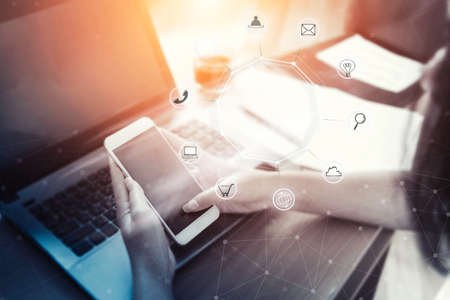 Business woman holding smart phone with icon flow.Communication network digital 4.0 technology.Internet wireless application development mobile and smartphone apps computing.Online E-commerce payment.の写真素材