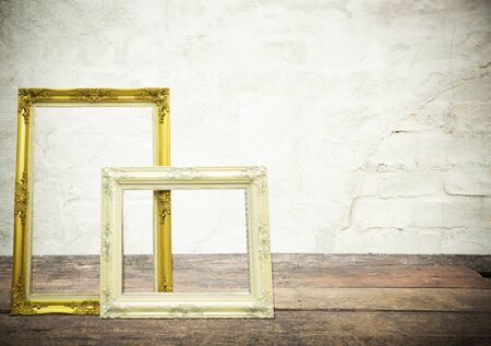Antique classical frame on wooden table with concrete texture on background.の写真素材