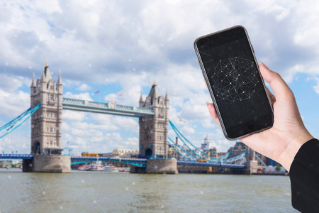 Hand holding smart phone and city with network connection. Smart city network connection concept.の写真素材