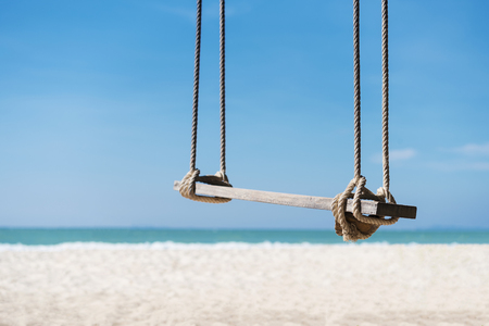 Travel and summer background, wooden swing on the beach with white sand, turquoise water and blue sky. Freedom life relax time. Picture for add text message. Backdrop for design art work.の写真素材