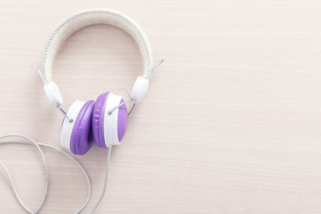 Purple and white headphone on wood table with free space for background. Music relax concept.の写真素材
