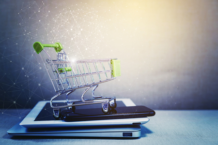 Online shopping background. E-commerce marketing technology, shopping cart on stacked mobile, tablet and laptop with connection line icon. Worldwide business. Global communication.の写真素材