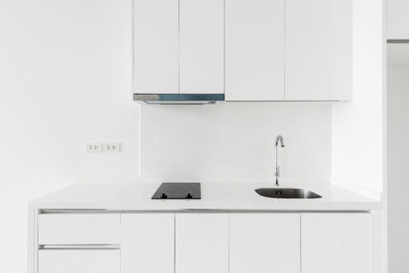 Kitchen interior concept. White counter with sink and electric stove, clear lighting. electric stoveの写真素材
