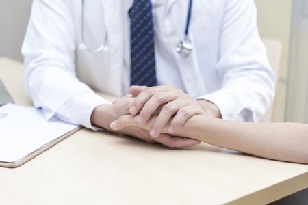 Healthy and medical concept. Doctor holding patient hand to give encourage in hospital.の写真素材