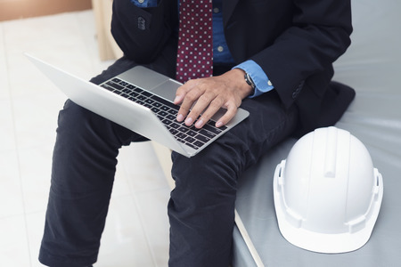 Businessman, engineering working with laptop and helmet in room.の写真素材