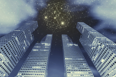 Connection technology background concept. High modern building in city at night with connection icons in the sky with cloud. Communication. Picture for add text message. Backdrop for design art work.の写真素材