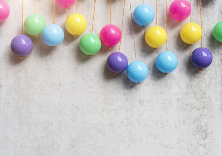 Abstract background from colorful balls hang on grey concrete wall. Party and celebrating backdrop. Picture for add text message. Backdrop for design art work.の写真素材