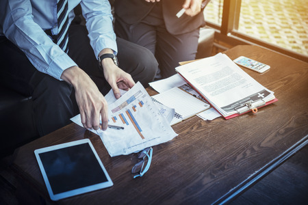 Close-up of Working woman using tablet for work with Business summary or Business plan report with Charts and graphs in office. Business concept.の写真素材