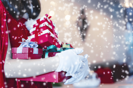 Merry Christmas concept. Santa holding gift boxes with falling snow.の写真素材