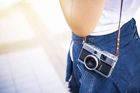 Closeup of traveler carrying camera with free copy space. Travel and lifestyle background.の写真素材