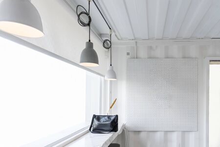 Comfortable cafe corner with glass window and white wallsの写真素材