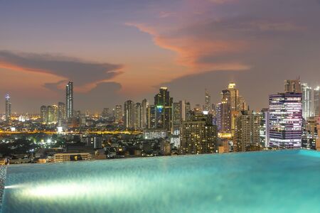 Bangkok city at sunset with swimming pool in foreground. Traveling to Thailand.の写真素材