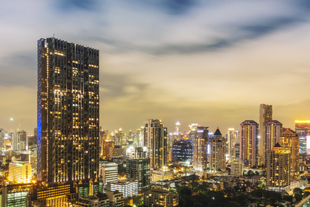 Modern hight building in business city center of Bangkok with moving cloud in the sky at night.のeditorial素材