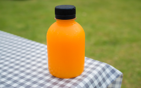 Orange bottle and chicken nuggets on the tableの写真素材