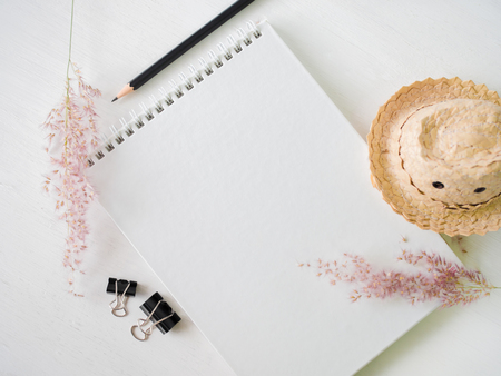 White note book and black pencil on white wooden table.の写真素材